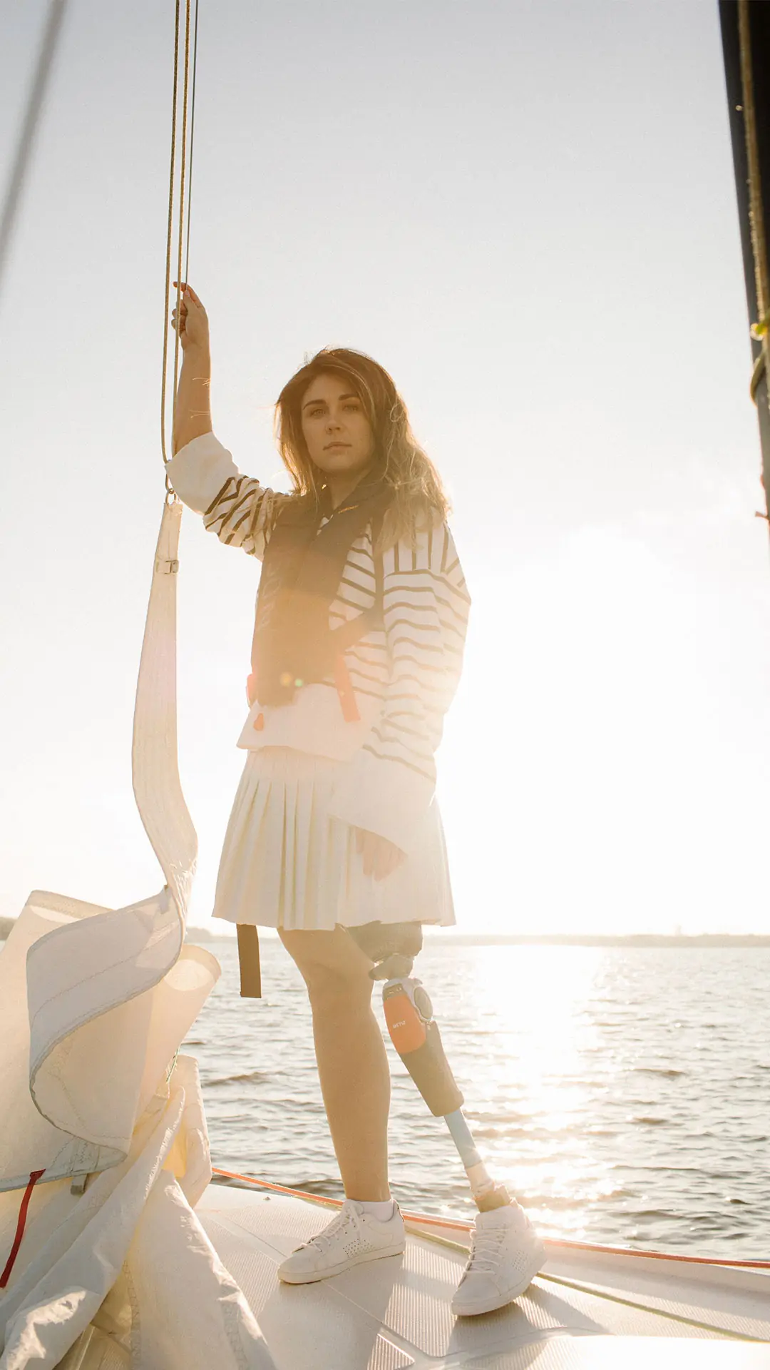 Woman standing on a sailboat, with a leg prosthesis and a Metiz 6H30 knee